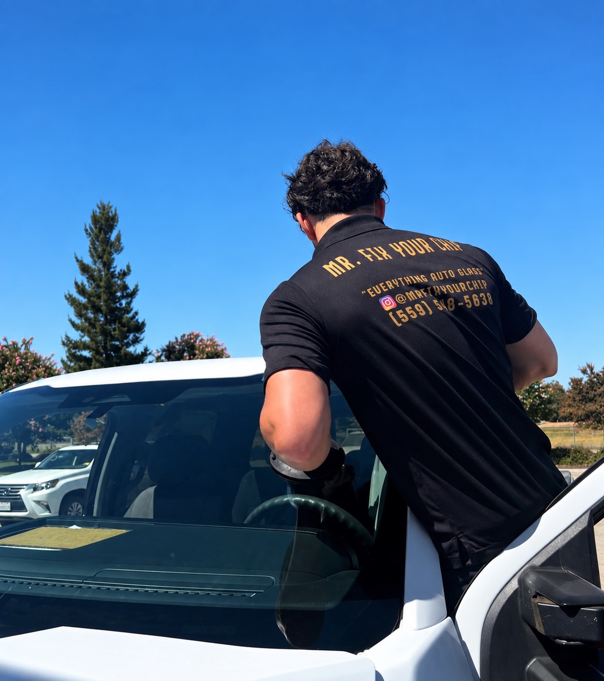 Technician installing a windshield on a white vehicle