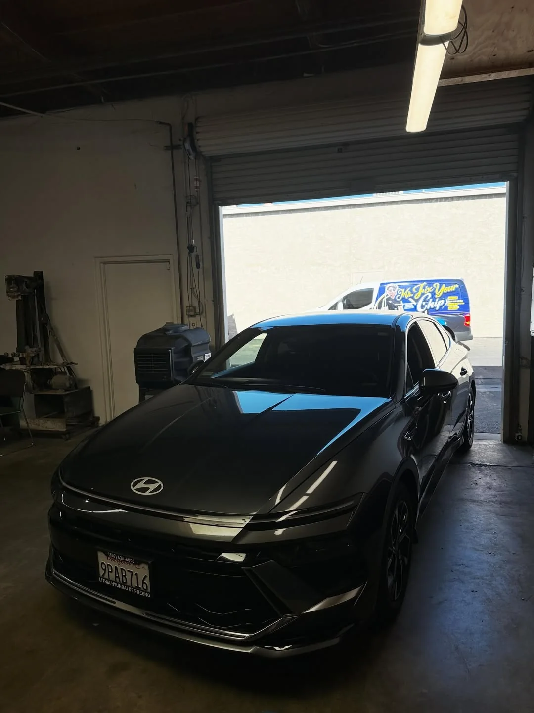 Dark sedan in the service area with the mobile van outside