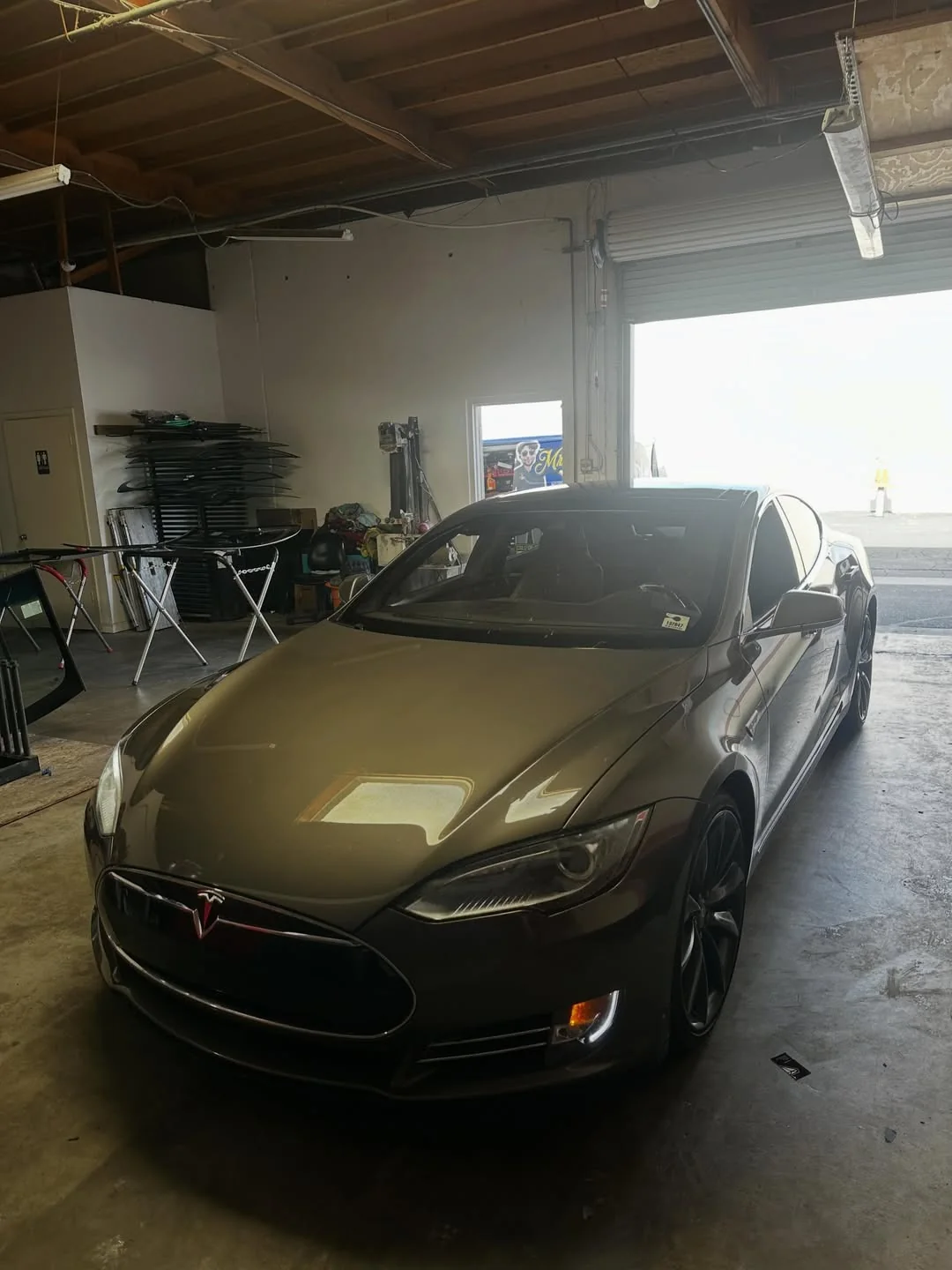 Dark electric sedan at a windshield appointment