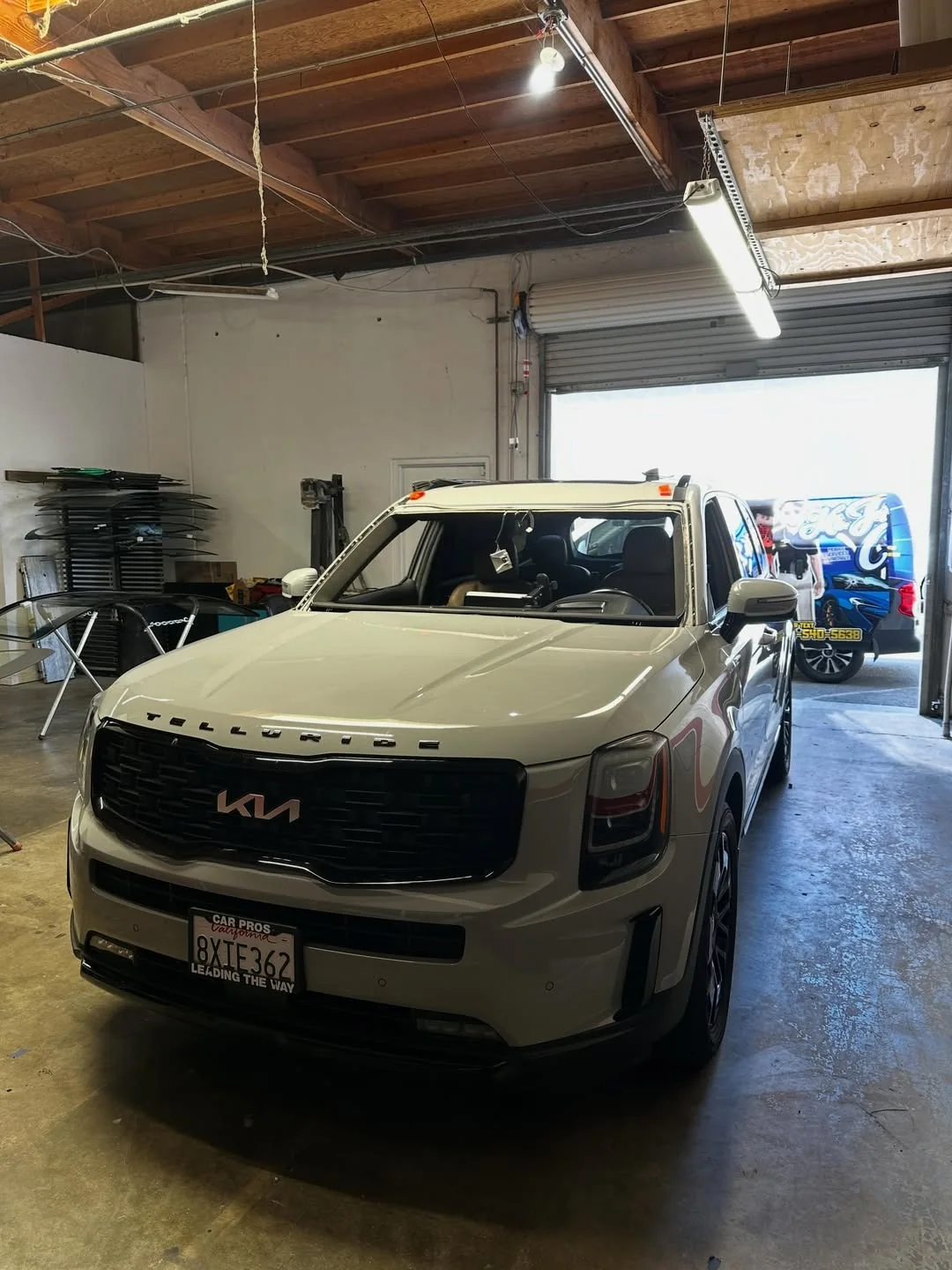 White SUV during windshield replacement with the service van nearby